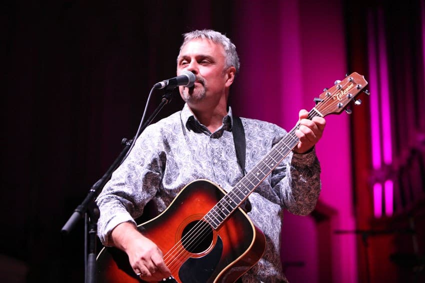 Acoustic guitar under magenta light